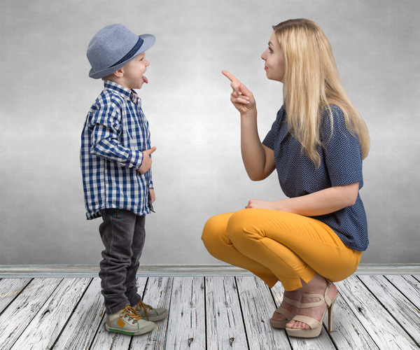 Enfant qui tire la langue et sa mère est dans une posture d’avertissement et de punition.